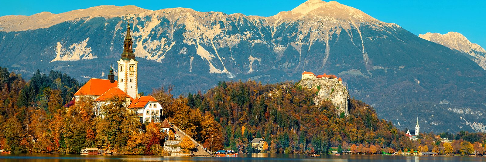Het meer van Bled met het oudste Sloveense kasteel en de Karawanken bergketen in Slovenië