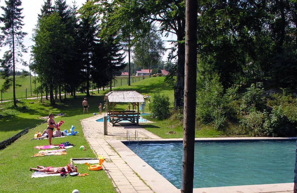 Buitenzwembad van Knaus Campingpark Lackenhäuser aan een meer in het Duitse Beieren bij de grens met Oostenrijk en Tsjechië