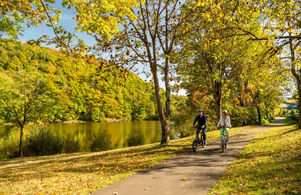 Fietspad aan het water bij Camping Landal Wirfttal in de Duitse Eifel in het westen van Duitsland bij de grens met Luxemburg en België
