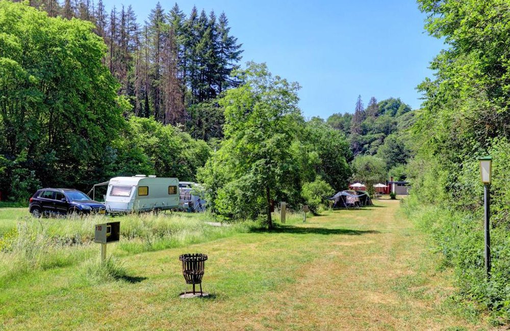 Tenten en caravans van Camping Drei Spatzen in de Duitse Eifel in het westen van Duitsland bij de grens met Luxemburg en België