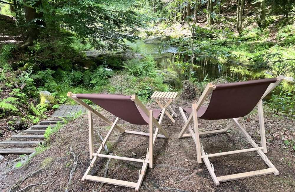 Stoeltjes aan het water bij Base Camp Medvědín in het Nationaal Park Reuzengebergte van Tsjechië