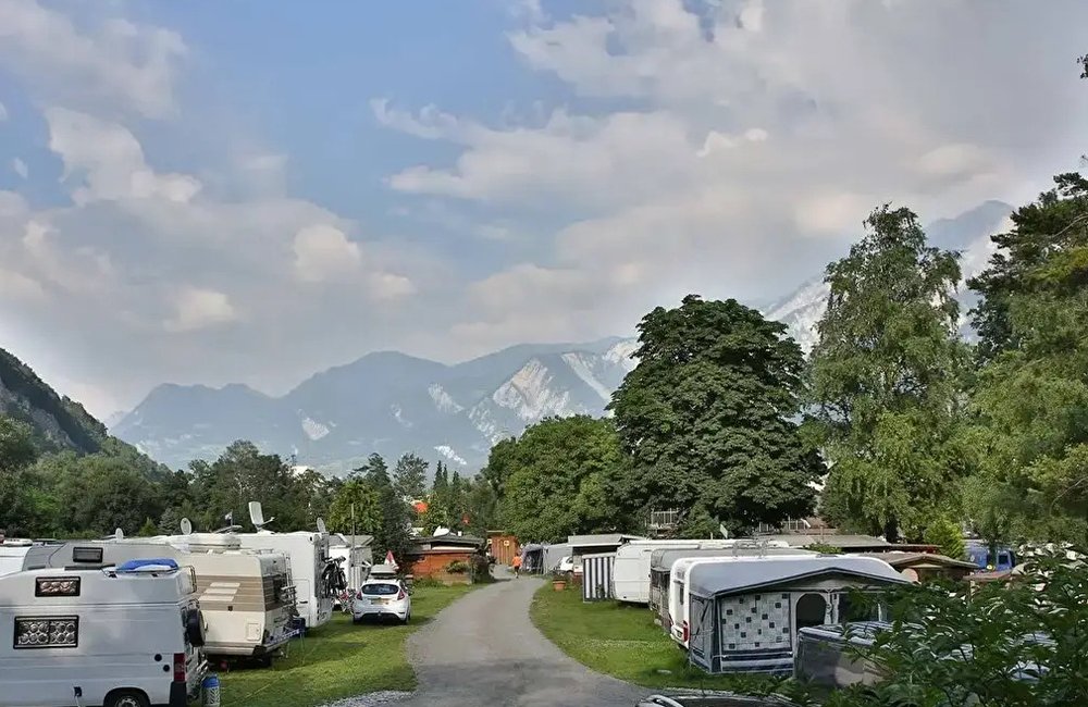 Caravans op Camp Au Chur in de Graubündener Alpen van Zwitserland aan de rivier de Rijn