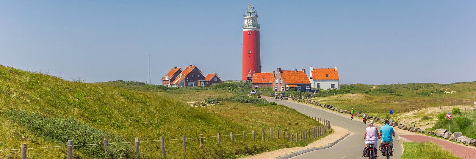 Een stel aan het fietsen naar de vuurtoren van Texel op de Waddeneilanden van Nederland in Noord Holland